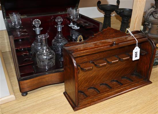 A walnut cased liqueur set and an oak pipe rack with tambour shutter